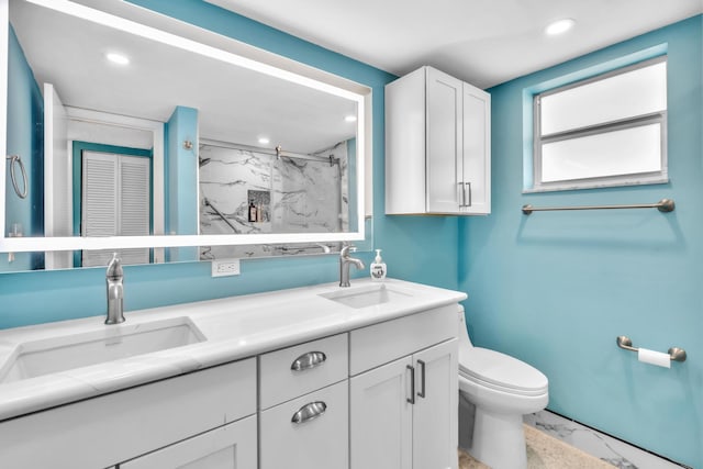 bathroom featuring tiled shower, vanity, and toilet