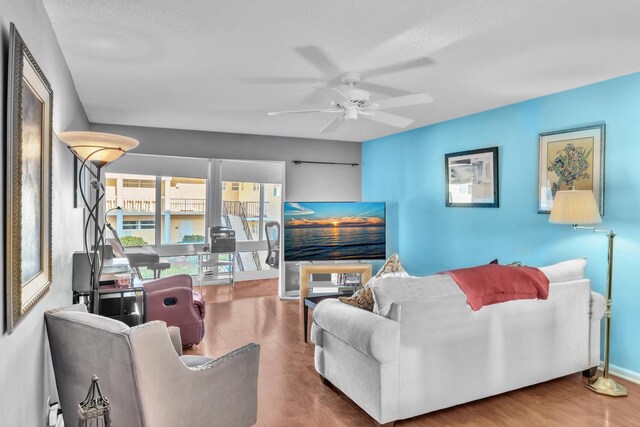 living room featuring hardwood / wood-style floors and ceiling fan