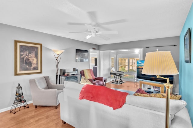 living room with wood-type flooring and ceiling fan