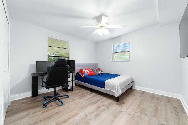 bedroom with ceiling fan, light hardwood / wood-style floors, and a closet