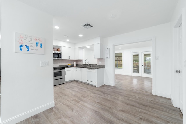 kitchen featuring sink, light hardwood / wood-style flooring, appliances with stainless steel finishes, white cabinets, and french doors