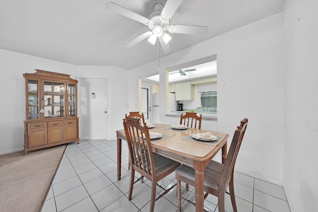 dining area with ceiling fan, light colored carpet, sink, and a textured ceiling