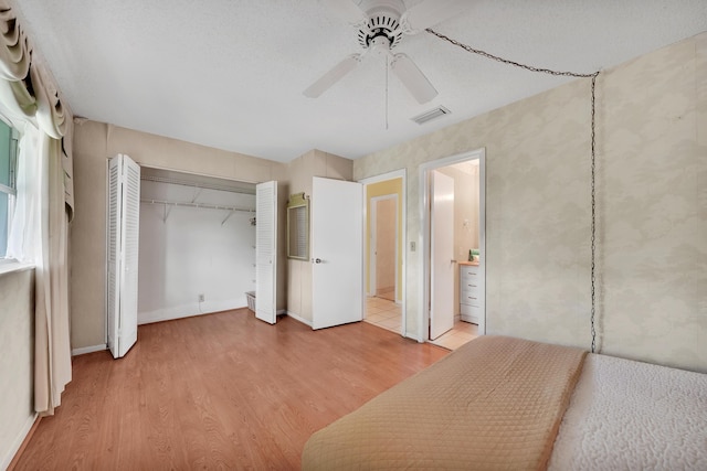 unfurnished bedroom with light hardwood / wood-style flooring, a closet, and ceiling fan