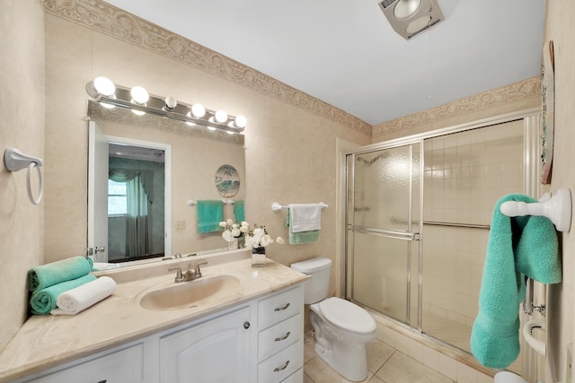 bathroom with vanity, toilet, tile patterned flooring, and a shower with door