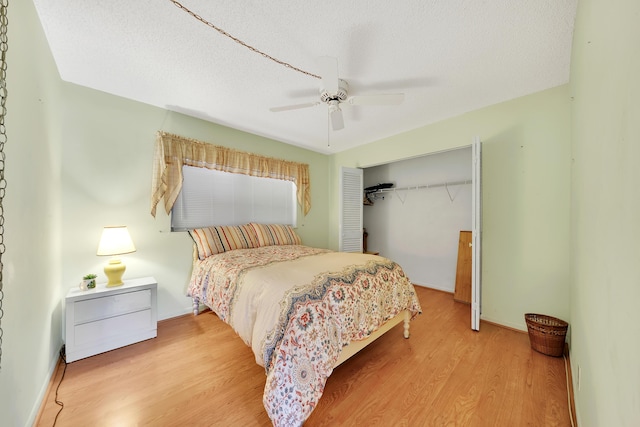 bedroom with ceiling fan, hardwood / wood-style floors, a closet, and a textured ceiling