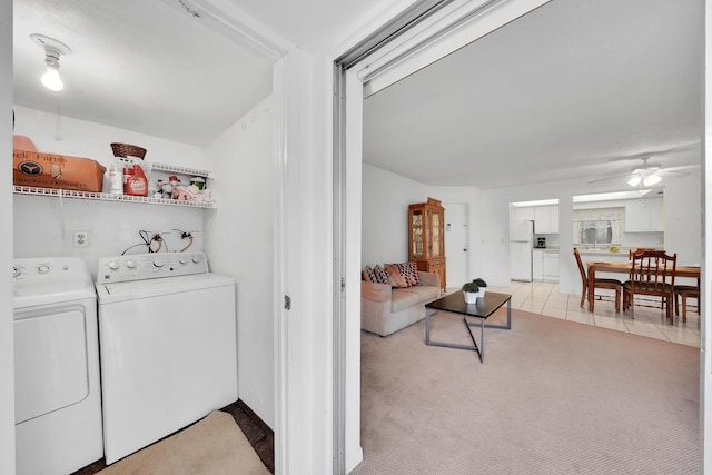 laundry room with ceiling fan, washing machine and dryer, and light tile patterned floors