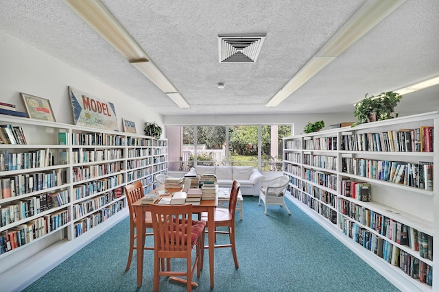 interior space featuring a textured ceiling and carpet flooring