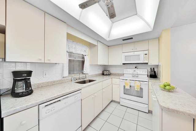 kitchen featuring sink, white appliances, light tile patterned floors, decorative backsplash, and kitchen peninsula