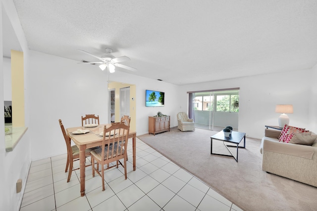 carpeted dining space with ceiling fan and a textured ceiling