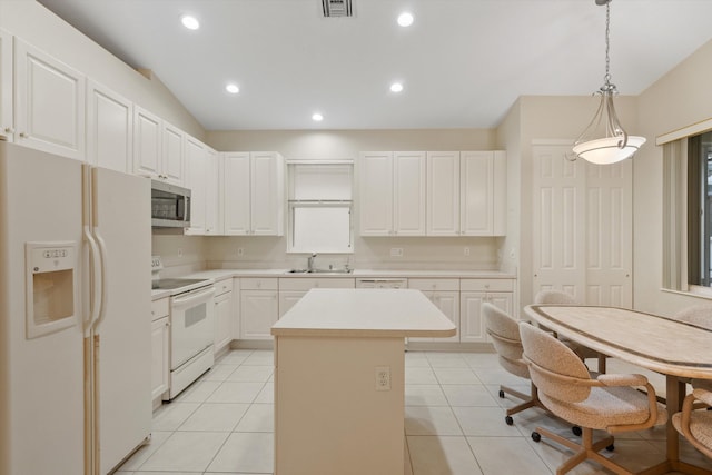 kitchen featuring white appliances, decorative light fixtures, a center island, and white cabinets