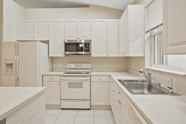 kitchen with sink, vaulted ceiling, light tile patterned floors, white appliances, and white cabinets