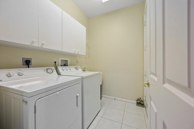 washroom featuring cabinets, light tile patterned floors, and washer and clothes dryer