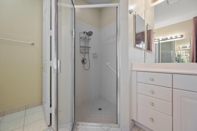 bathroom featuring walk in shower, vanity, and tile patterned flooring