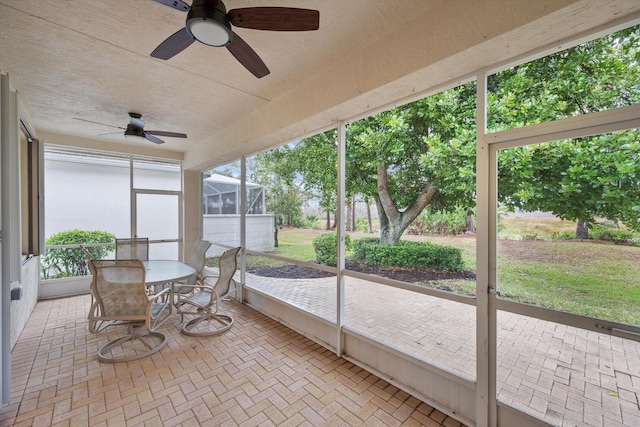 unfurnished sunroom with plenty of natural light and ceiling fan