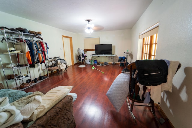 living room featuring ceiling fan and dark hardwood / wood-style flooring