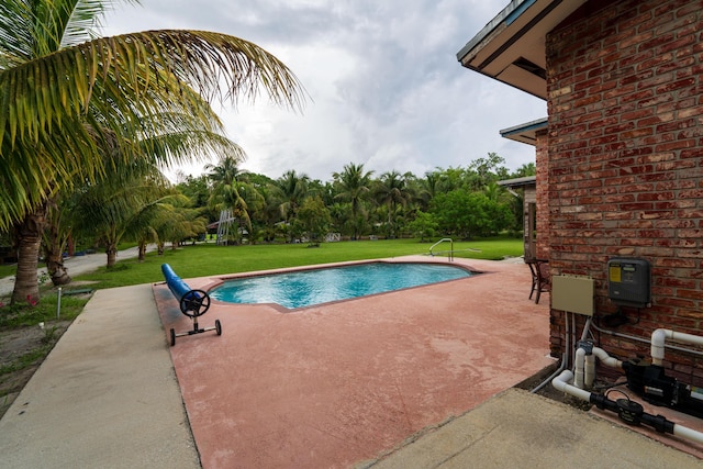 view of pool featuring a yard and a patio