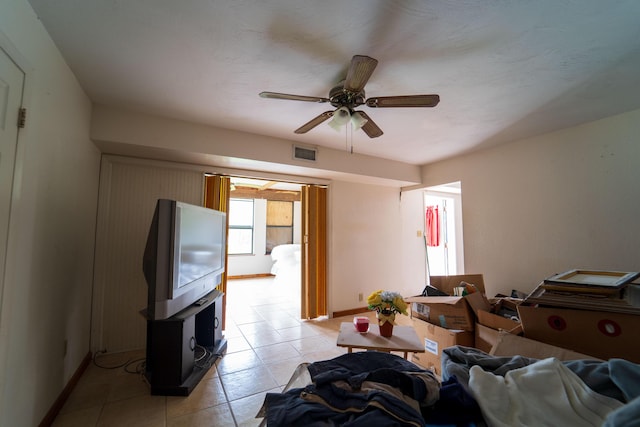 tiled living room with ceiling fan