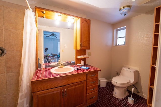 bathroom with a shower with shower curtain, toilet, vanity, baseboards, and tile patterned floors