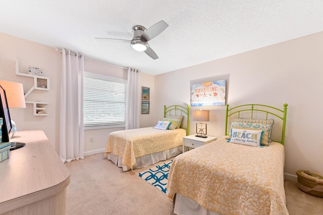 carpeted bedroom with ceiling fan and a textured ceiling