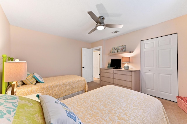 carpeted bedroom featuring ceiling fan and a closet