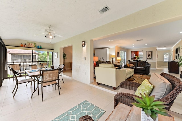 tiled dining area with ceiling fan, ornamental molding, and a textured ceiling