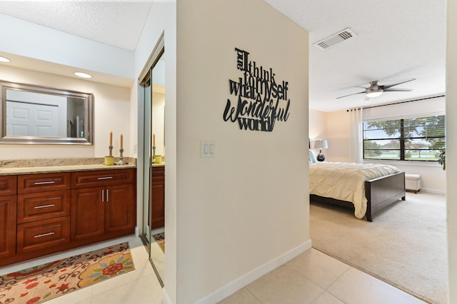 carpeted bedroom featuring connected bathroom and a textured ceiling