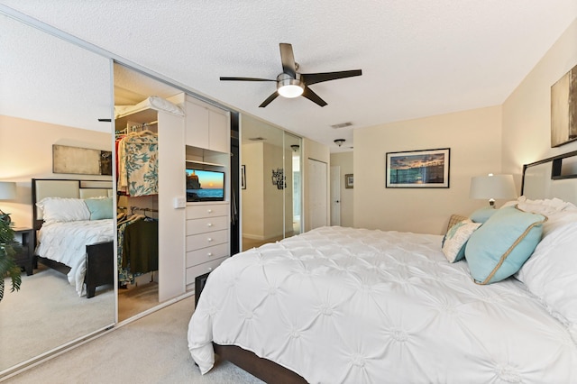 carpeted bedroom with ceiling fan and a textured ceiling