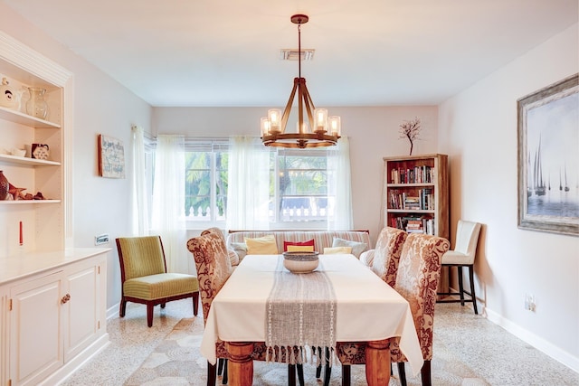 dining room with built in shelves and a notable chandelier