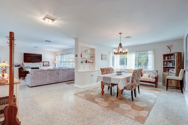 dining room with built in features and a notable chandelier