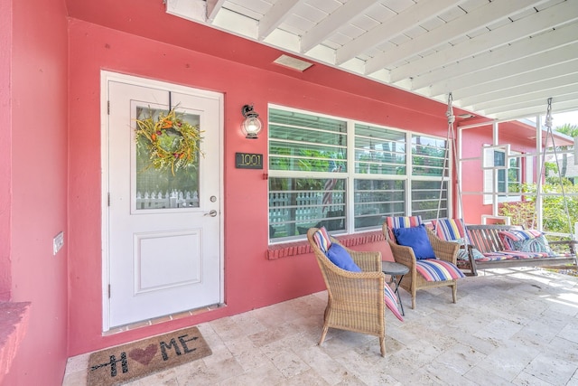 view of exterior entry featuring covered porch