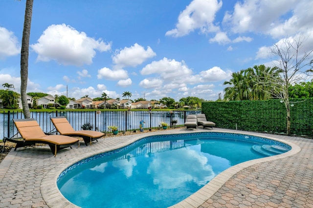 view of pool with a patio area and a water view