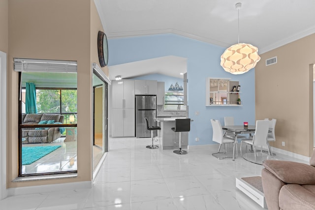 dining room with ornamental molding and lofted ceiling