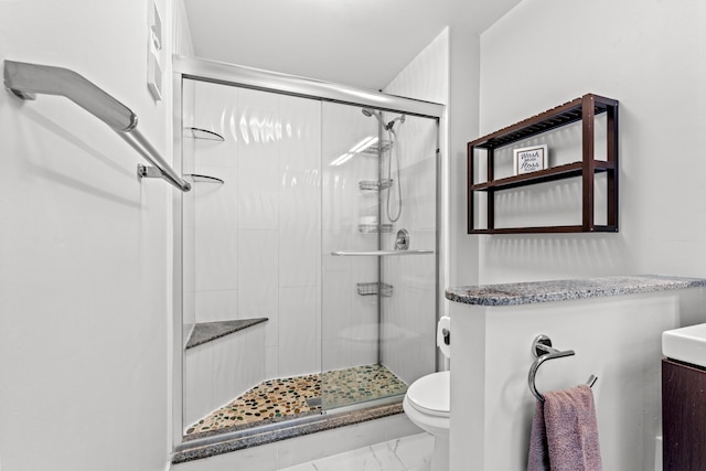 bathroom with a shower with shower door and toilet