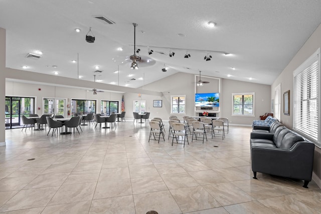 dining room with high vaulted ceiling, light tile patterned flooring, and a healthy amount of sunlight