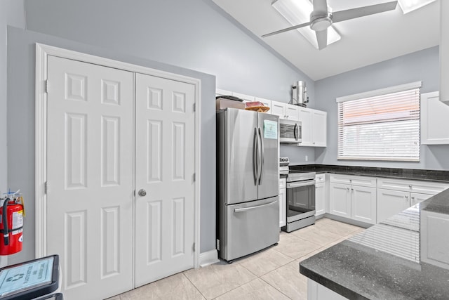 kitchen featuring vaulted ceiling, white cabinetry, stainless steel appliances, light tile patterned flooring, and ceiling fan