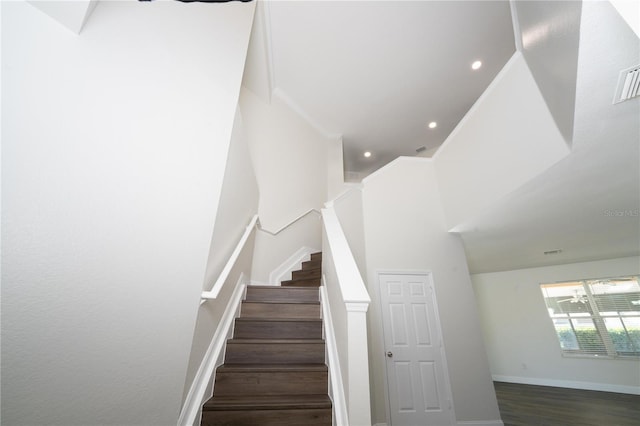 stairs featuring hardwood / wood-style flooring and a high ceiling