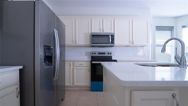 kitchen with white cabinetry, sink, decorative backsplash, light tile patterned floors, and stainless steel appliances