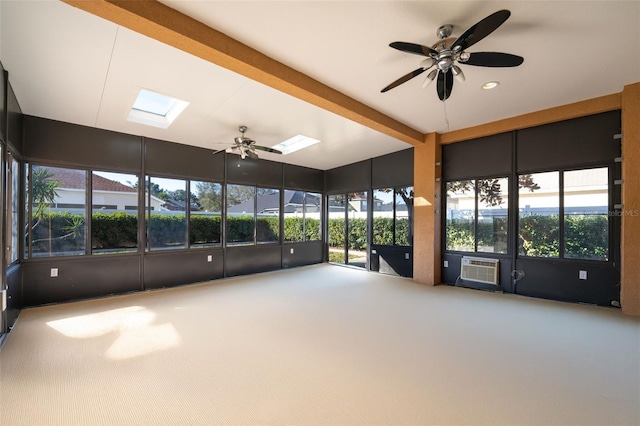 unfurnished sunroom with cooling unit, ceiling fan, beam ceiling, and a skylight