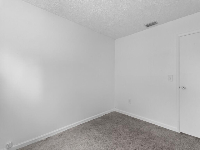 carpeted spare room with a textured ceiling