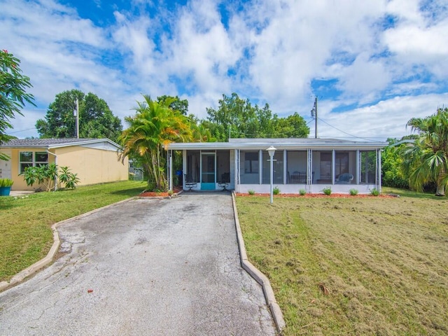 single story home with a front lawn and a sunroom