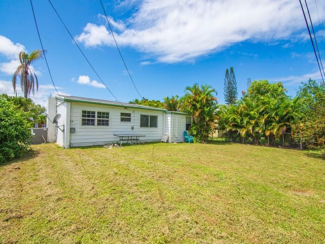 rear view of house featuring a yard