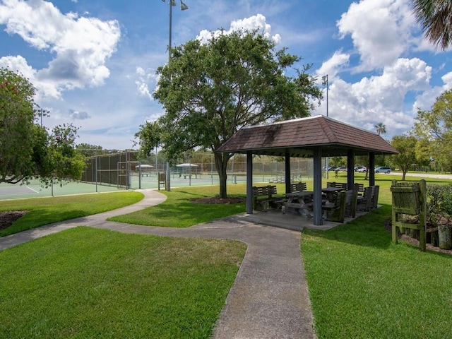 view of home's community with a gazebo, tennis court, and a lawn