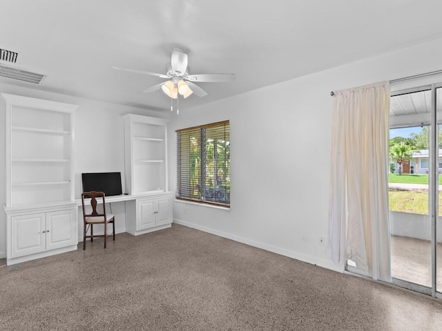 unfurnished office with built in shelves, ceiling fan, and built in desk