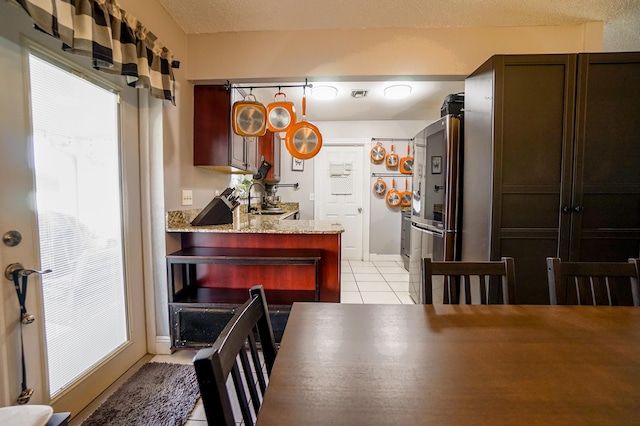 tiled dining space with sink and a textured ceiling