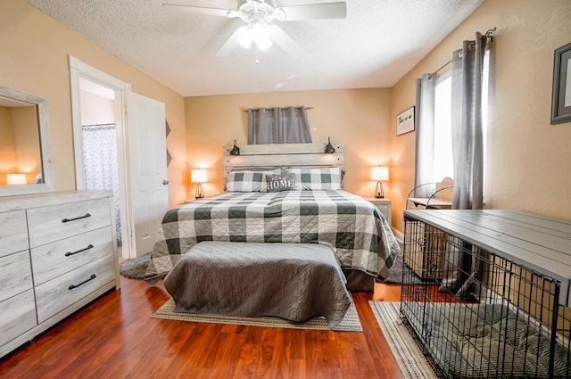 bedroom with ceiling fan, dark hardwood / wood-style floors, and a textured ceiling