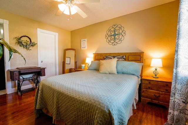 bedroom with dark wood-type flooring, ceiling fan, and a textured ceiling