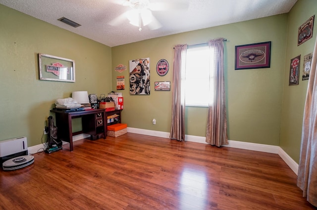 interior space with wood-type flooring, ceiling fan, and a textured ceiling