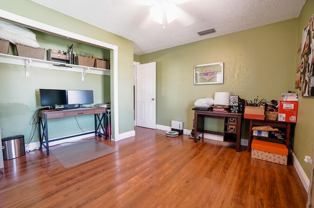 office space featuring ceiling fan, hardwood / wood-style flooring, and a textured ceiling