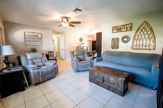 tiled living room featuring ceiling fan with notable chandelier and a textured ceiling