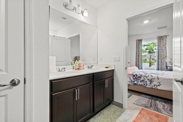 bathroom featuring double vanity, ensuite bath, visible vents, and a sink